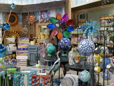 A gift shop display filled with colorful metal garden art