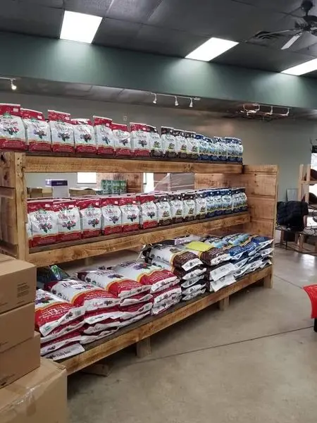 Aisle of bagged soils and garden mixes on wooden store shelving