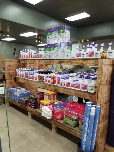 Wooden store shelving stocked with lawn and garden care supplies