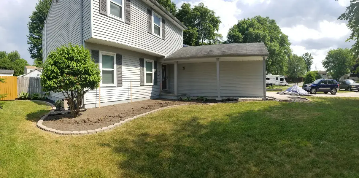 Freshly mulched foundation bed with an edged border around a home